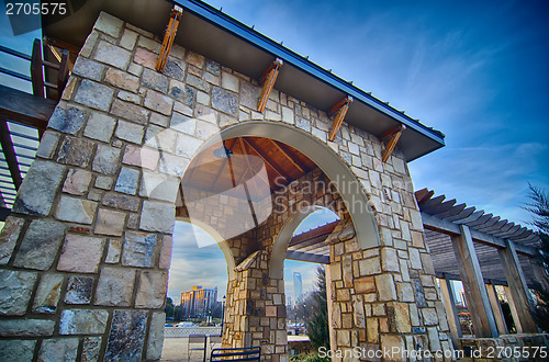 Image of cultured stone terrace trellis details near park in a city 