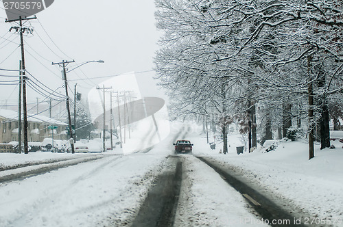 Image of snow covered road and trees after winter storm