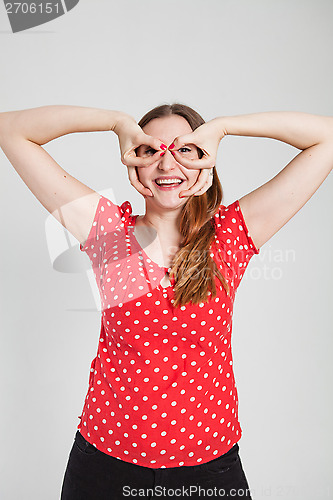 Image of Smiling attractive woman through finger goggles