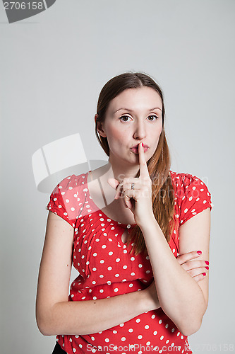 Image of Attractive woman with finger over pursed lips