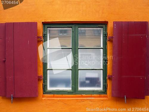 Image of Colorful red shutters on a window.