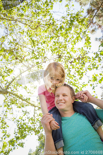 Image of Cute Young Girl Rides Piggyback On Her Dads Shoulders