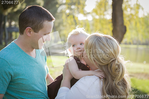 Image of Cute Young Baby Boy Being Hugged By His Parents