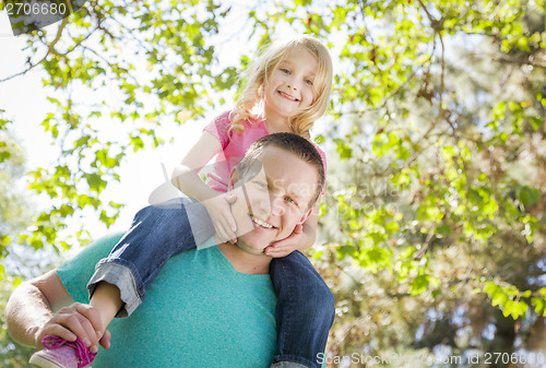 Image of Cute Young Girl Rides Piggyback On Her Dads Shoulders