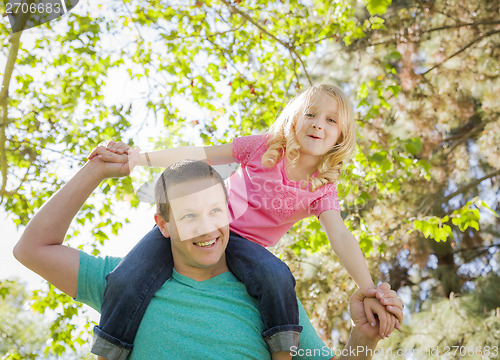 Image of Cute Young Girl Rides Piggyback On Her Dads Shoulders