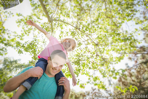 Image of Cute Young Girl Rides Piggyback On Her Dads Shoulders