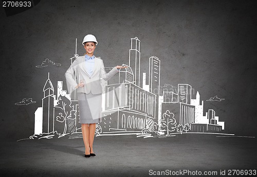 Image of businesswoman in helmet showing town drawing