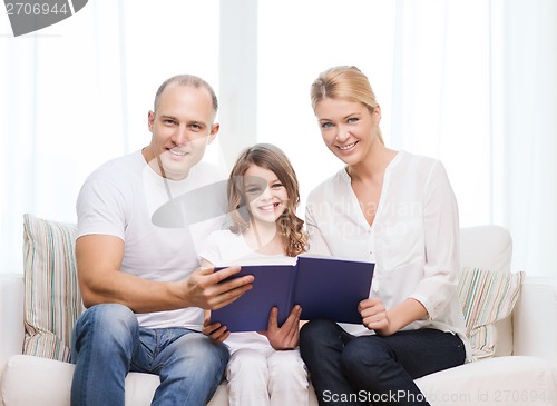 Image of smiling parents and little girl with at home