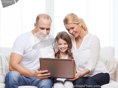 Image of parents and little girl with laptop at home