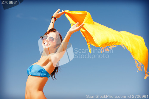 Image of happy woman with yellow sarong on the beach