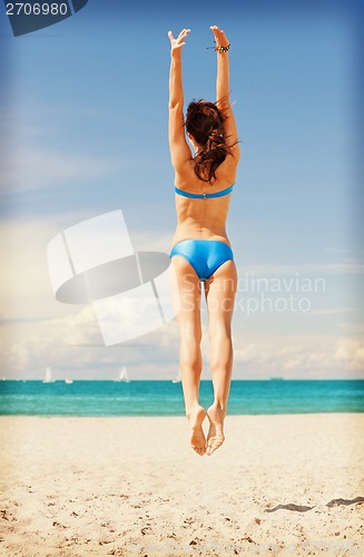 Image of jumping woman on the beach