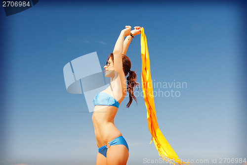 Image of happy woman with yellow sarong on the beach