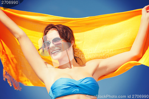 Image of happy woman with yellow sarong on the beach