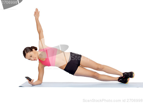 Image of asian sporty woman with smartphone doing exercise