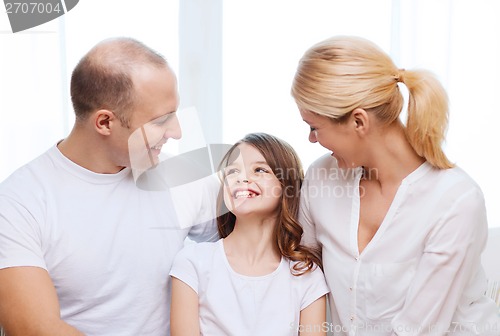 Image of smiling parents and little girl at home