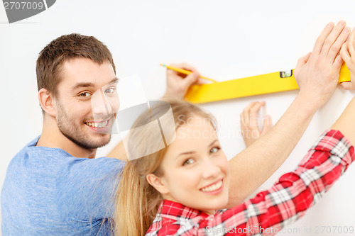 Image of couple building using spirit level to measure