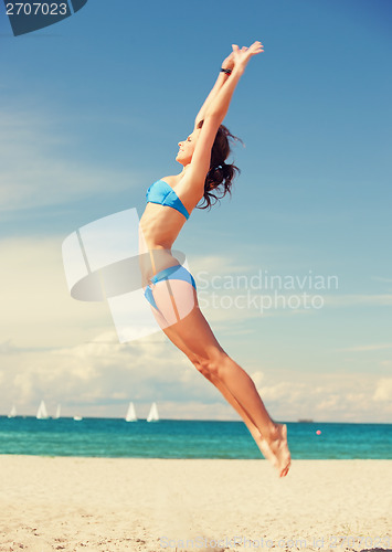 Image of happy jumping woman on the beach