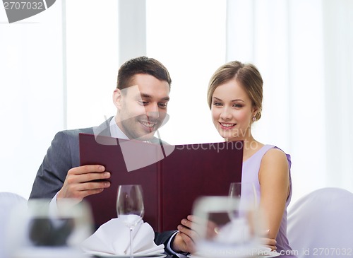 Image of smiling couple with menu at restaurant