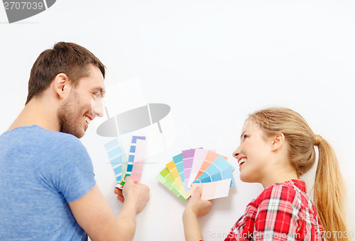 Image of smiling couple looking at color samples at home