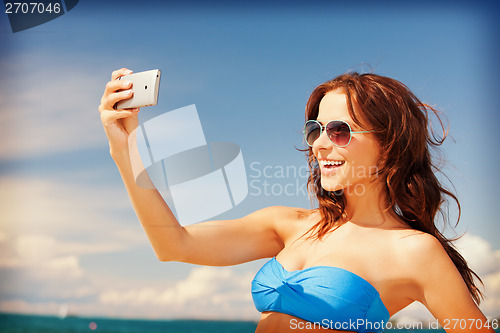 Image of happy woman with phone on the beach