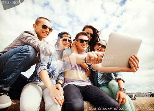 Image of group of teenagers looking at tablet pc