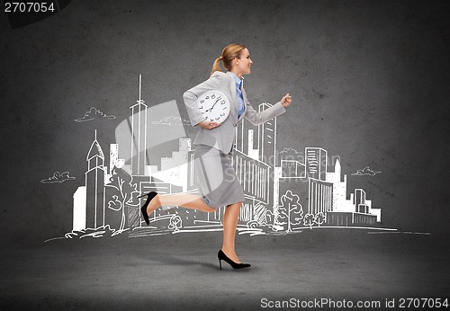 Image of smiling young businesswoman with clock running
