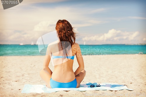 Image of woman sitting on a towel