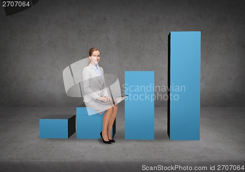 Image of smiling woman sitting on growing chart with laptop