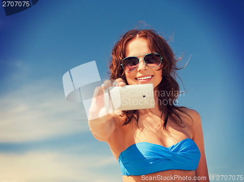 Image of happy woman with phone on the beach