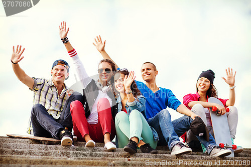 Image of group of teenagers waving hands