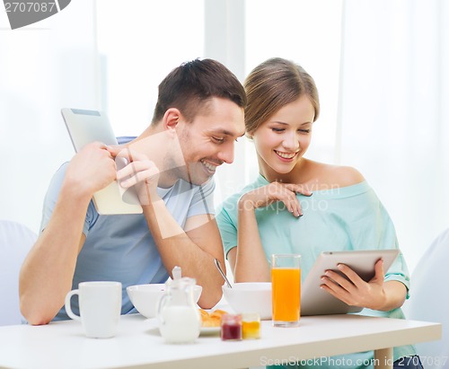 Image of smiling couple with tablet pc reading news