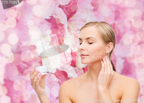 Image of woman applying cream on her skin