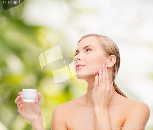 Image of woman applying cream on her skin