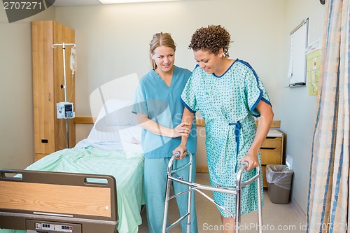 Image of Nurse Helping Patient To Walk Using Walker In Hospital