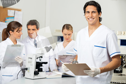 Image of Male Scientist Holding Clipboard In Lab