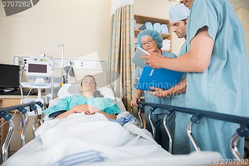Image of Nurses Discussing Patient's Report By Bed
