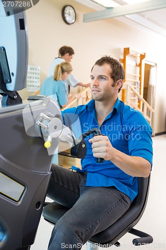 Image of Young Man On Exercise Bike In Hospital
