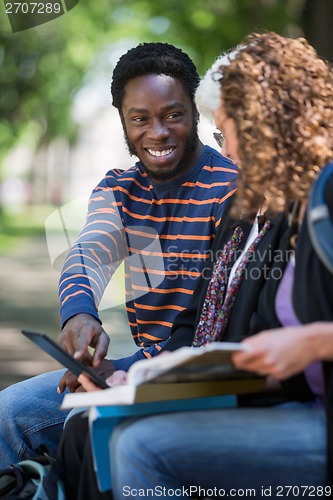 Image of Student Using Digital Tablet With Friends On Campus