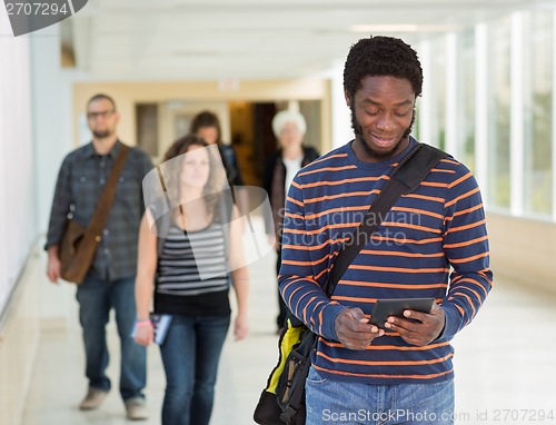 Image of Student Using Digital Tablet Down University Corridor