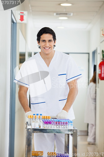 Image of Technician Pushing Medical Cart In Hospital Hallway