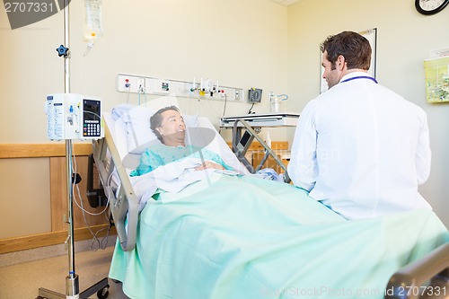 Image of Smiling Patient Looking At Doctor While Lying On Hospital Bed