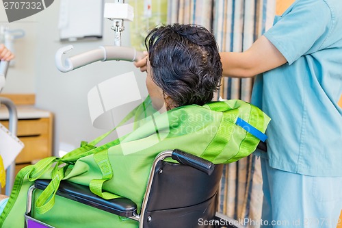 Image of Nurse Holding Hydraulic Lift's Handle With Patient On Wheelchair