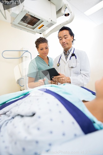 Image of Medical Team Using Digital Tablet In Examination Room