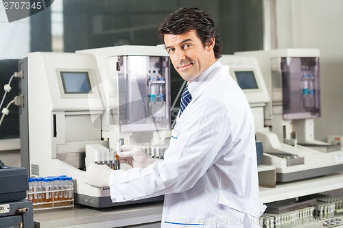 Image of Scientist Using Urine Analyzer To Test Samples