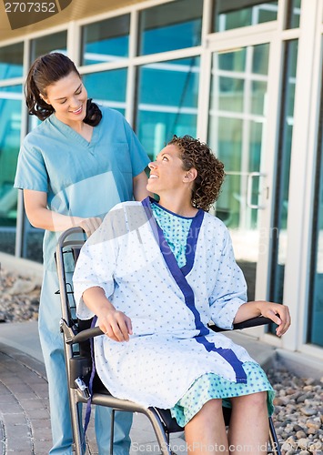 Image of Patient Looking At Friendly Nurse While Sitting On Wheelchair