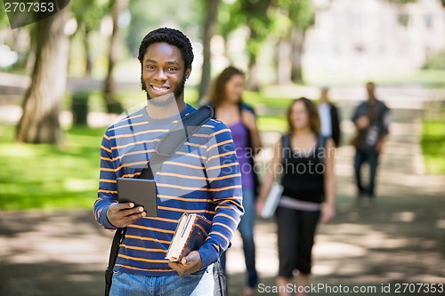 Image of Happy Student Holding Digital Tablet On Campus