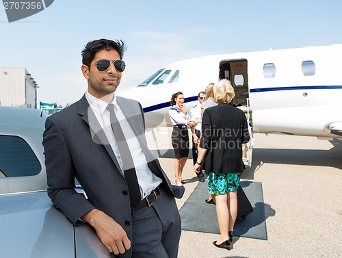 Image of Businessman Leaning On Car At Airport Terminal