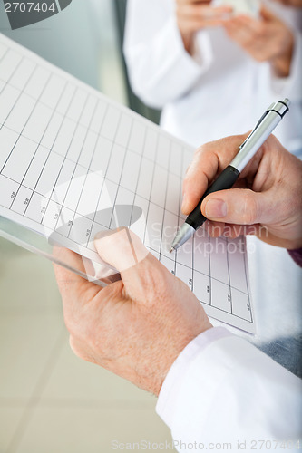 Image of Researcher Writing On Clipboard