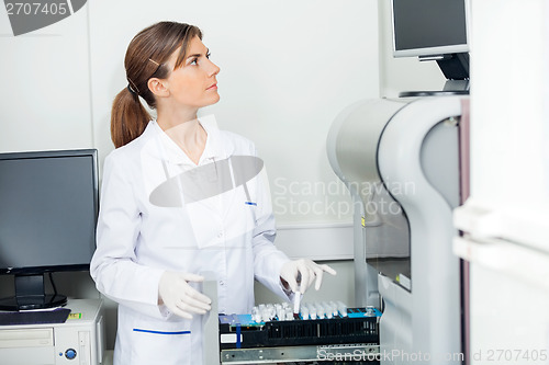 Image of Scientist Loading Coagulation Analyzer With Test Samples