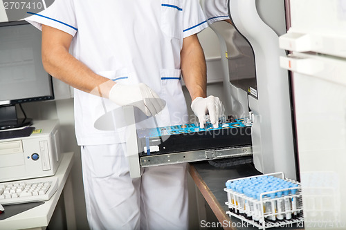 Image of Scientist Loading Samples Into Analyzer